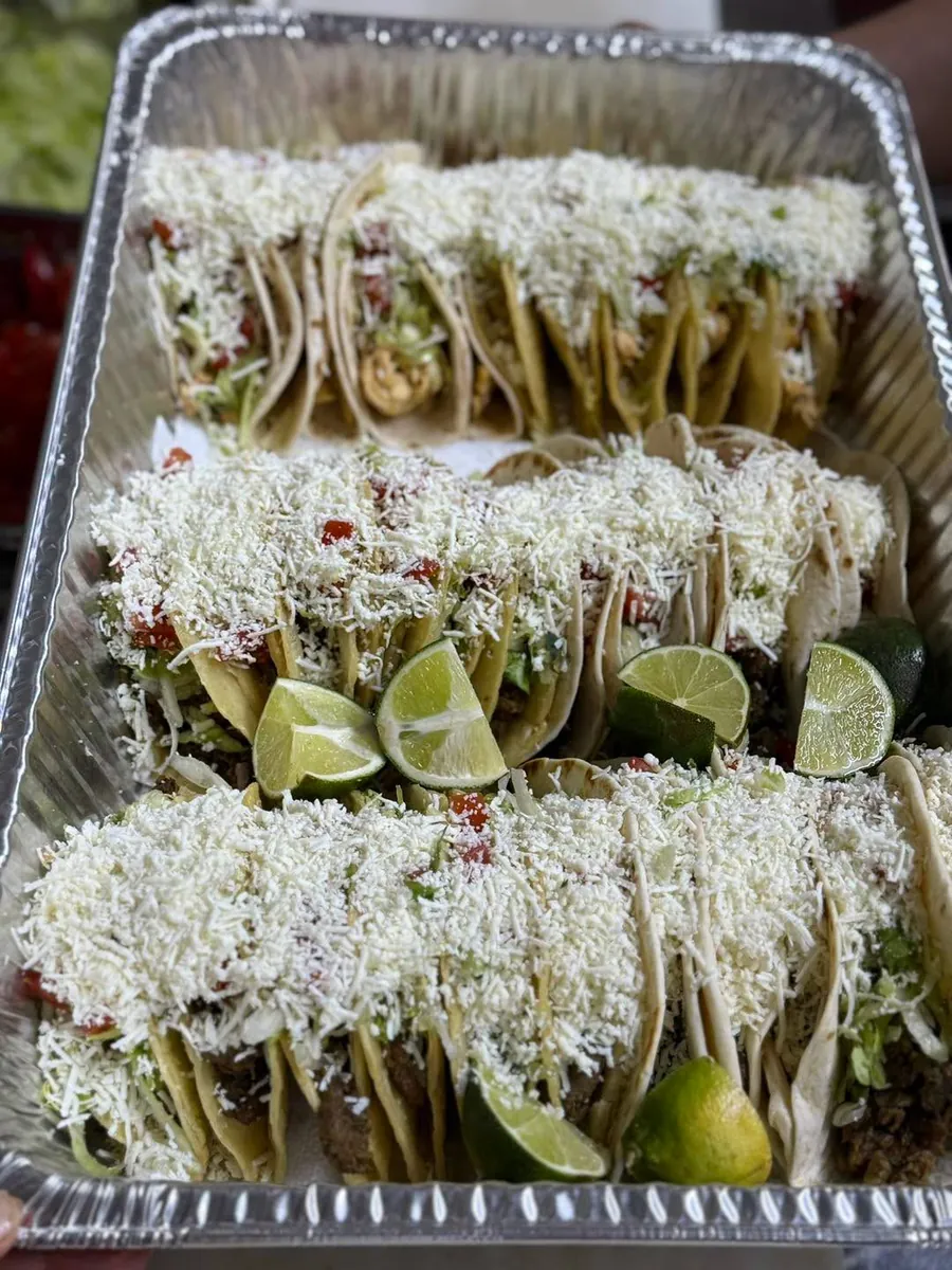 A real La Tapatía steak and chicken taco tray topped with fresh lime wedges