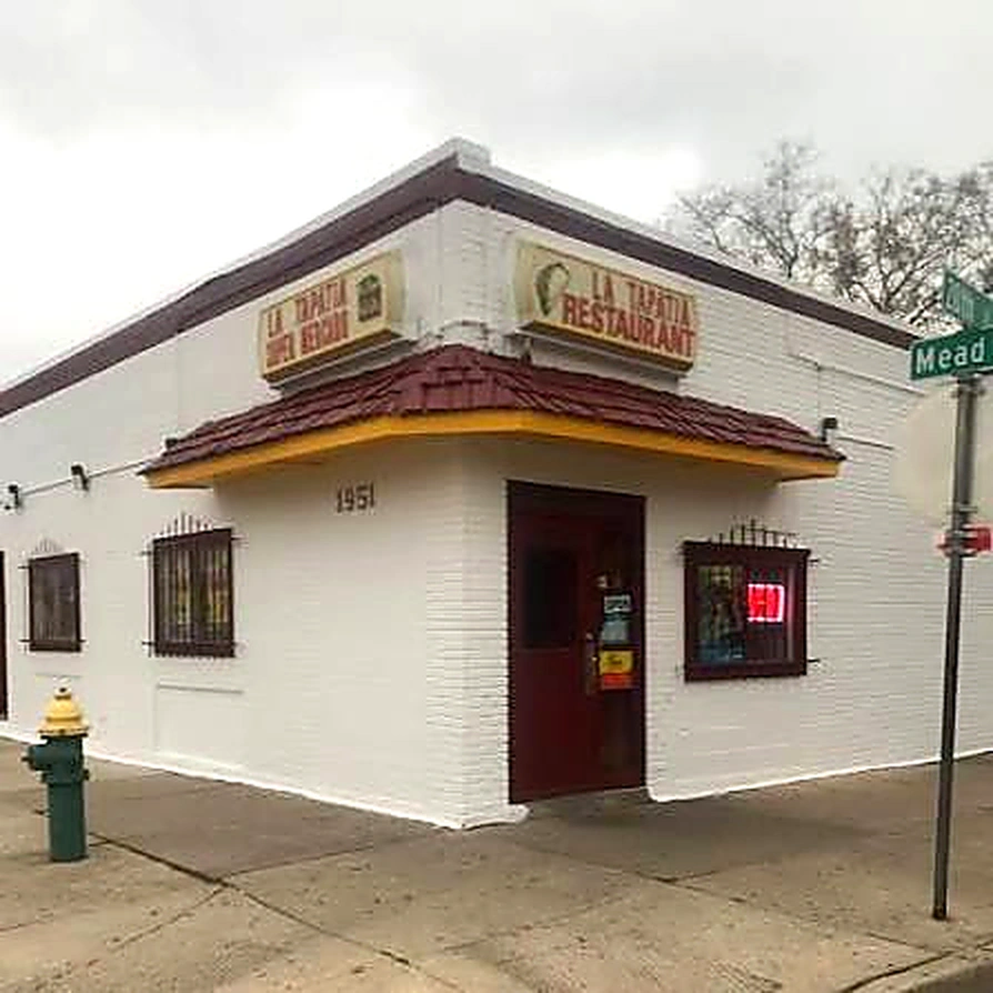 La Tapatía at 1951 Mead Street in Racine: a white brick corner building with a yellow awning and the entrance door set into the corner